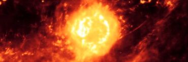 Supernova remnant Cassiopeia A imaged by the Spitzer Space Telescope and MIPS instrument. Cassiopeia A, the roughly circular yellow ball, is in the center of the image and surrounded by red-orange clouds of dust.
