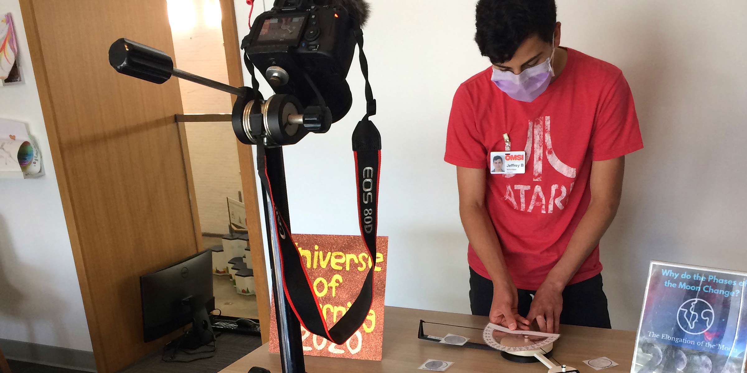 Young man at a table in front of a camera working on a phases of the moon activity