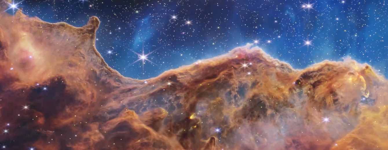 The image is divided horizontally by an undulating line forming peaks and valleys in the top third. At the bottom is a brown cloudscape forming a nebula. At the top is a comparatively clear upper portion in blue. Speckled across both portions are innumerable stars of many sizes.